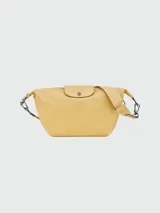 Bandolera Longchamp modelo Le Pliage Xtra S, color amarillo pastel, con correa ajustable y cierre con botón a presión.