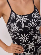 Malla entera de natación color negro con estampado de motivos playeros en blanco, con breteles finos y corte de pierna alto.