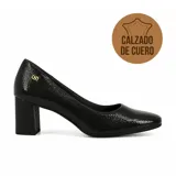 Zapato de tacón alto Usaflex, color negro con textura grabada, punta redondeada y detalle de logo metálico dorado en el lateral.