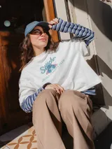 Remera blanca de corte holgado con estampado frontal de Stitch y texto Ohana Varsity Club. Presenta cuello redondo y mangas cortas.
