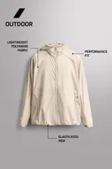 Chaqueta cortavientos de Zara Athleticz color beige, de tejido técnico ligero y elástico, con cuello subido, capucha, cierre frontal de cremallera y bolsillos laterales con cierre oculto.