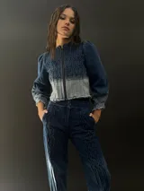 Campera de jean azul con lavado artesanal, entallada y corta hasta la cintura alta. Presenta textura central en el delantero.