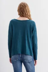 Remera de algodón peruano con textura jaspeada, de corte holgado y diseño de mangas largas con ajuste en la muñeca.