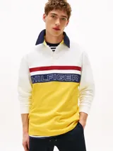 Chomba de rugby Tommy Hilfiger Sailing, unisex, de corte amplio y hombros caídos. Diseño color block blanco, amarillo y azul, con logo de la marca bordado en el pecho.