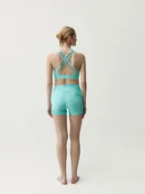 Top deportivo color turquesa, de corte ajustado, con cuello redondo y espalda nadadora.