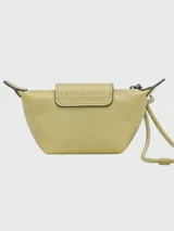 Monedero pequeño de cuero color verde oliva, con solapa frontal que presenta el logo de la marca grabado y cierre de cremallera superior. Incluye una correa fina para llevarlo colgado.