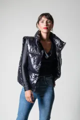 Chaleco negro puffer con cuello alto y cierre frontal con cremallera.