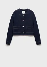 Chaqueta corta de denim color azul oscuro, con cuello redondo, cierre frontal de botones y dos bolsillos de parche delanteros.
