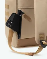 Mochila de diseño urbano en color beige con detalles en cuero sintético marrón. Cuenta con un bolsillo frontal con solapa y cierre de hebilla, asas superiores de mano y correas ajustables para hombros.