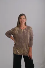 Sweater de viscosa color visón con escote en V y mangas largas. Presenta un estampado de rayas verticales y salpicaduras en color dorado.