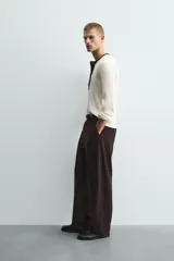 Camiseta de manga larga en tejido de punto canalé color crudo, con cuello redondo y tapeta frontal con botones en color marrón oscuro a contraste.