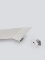 Par de aros asimétricos plateados. Uno es un botón pequeño y el otro es un prisma rectangular.