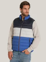 Chaleco acolchado Tommy Hilfiger con diseño triblock en azul marino, gris y azul. Cuenta con cuello alto, cierre de cremallera frontal, dos bolsillos laterales con cremallera y logo bordado en el pecho.