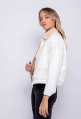 Campera de jean con corderito en el cuello y el interior, bolsillos frontales, cierre de botones metálicos y elástico en la cintura.