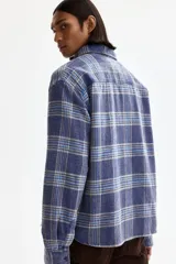 Camisa de sarga de algodón con diseño a cuadros, cuello inglés, bolsillo superior y mangas largas con puños abotonados.