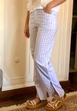 Pantalón celeste a cuadros confeccionado en popelina, con tajo de 25 cm en los laterales.