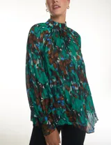 Blusa de gasa plisada con estampado abstracto en tonos verdes, azules y marrones. Presenta cuello alto, mangas largas abullonadas con puños abotonados y un corte holgado con caída fluida.