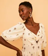 Vestido midi de algodón color crudo con estampado de cocoteros, escote con detalle torcido y mangas 3/4.