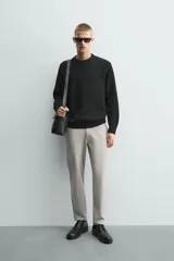 Pantalón chino de corte slim fit, confeccionado en tejido elástico. Presenta bolsillos frontales, bolsillos traseros de vivo con botón y cierre frontal con cremallera y botón.