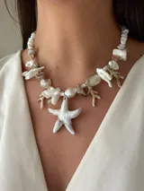 Collar corto con cuentas de nácar en diferentes formatos, perla natural XL y medallón de resina. Se cierra con cadena de acero quirúrgico y ganchito para regular el largo.