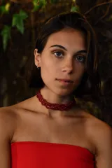 Gargantilla tipo choker tejida con cuentas de vidrio en color rojo, con diseño entrelazado y cadena de alargue posterior.