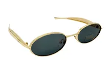 Lentes de sol estilo retro con armazón metálico dorado y formato ovalado. Cuentan con cristales oscuros y protección UV400.