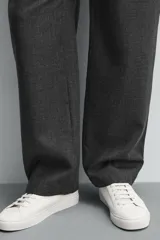 Zapatilla de estilo minimalista en color negro, con cordones al tono, suela de goma en color crema y detalle de talón en contraste.