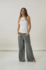 Musculosa de morley color blanco, con escote estilo halter y detalle de texto bordado en negro en el pecho.