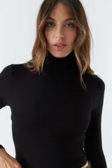 Polera negra de cuello alto y manga larga, de corte ajustado.