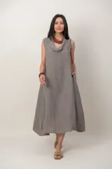 Vestido midi de lino verde grisáceo, sin mangas, con escote buche, corte relajado y bolsillos laterales.