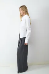 Pantalón de vestir de tiro alto con pliegues frontales, corte amplio y pernera recta. Cuenta con bolsillos laterales y cierre frontal con cremallera y botón.