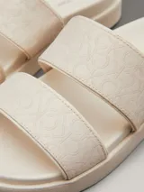Sandalias planas Calvin Klein color blanco con doble tira ancha con logo jacquard en relieve.