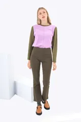 Pantalón jean acampanado color ladrillo, de tiro alto, con cierre lateral invisible, pretina ancha con costuras decorativas y un único pasacinto en la parte posterior con bordado a tono.