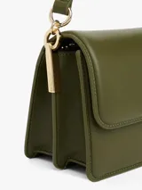 Cartera tipo bandolera o de hombro color verde oliva, de acabado liso y forma rectangular. Presenta una solapa frontal con cierre magnético y un broche metálico dorado con el monograma TH. Incluye correa ajustable y herrajes dorados.