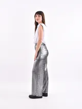 Pantalón de corte recto y tiro alto, confeccionado en tela metalizada color dorado con acabado brillante.