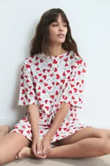 Camisón de algodón con estampado de corazones rojos y frases románticas sobre fondo blanco, de corte holgado y manga corta.