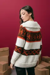 Saco tejido a mano con diseño jacquard, de corte recto y largo a la cadera. Presenta cuello redondo, cierre frontal con botones y mangas largas. Incluye tajos laterales en el ruedo.