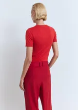 Jersey de punto fino color rojo, de manga corta, diseño entallado y cuello redondo.