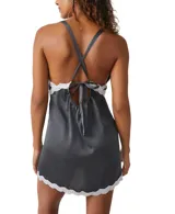 Minivestido gris con detalles en azul y encaje blanco, escote en V profundo, sin mangas, cierre de amarre ajustable y aberturas laterales en ambas piernas.