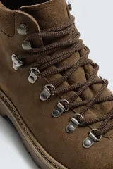 Bota de caña baja con acabado en serraje, horma redonda y suela track con volumen.