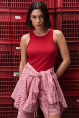 Musculosa de calce ajustado color rojo, confeccionada en algodón con elastano. Presenta escote redondo alto y textura acanalada.