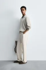 Polo de punto regular fit en color beige, confeccionado con una mezcla de algodón y cáñamo. Presenta cuello solapa con abertura frontal, manga larga y acabados en rib.