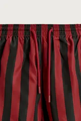 Short de baño confeccionado en tejido técnico, con diseño de rayas verticales en color verde y negro. Cuenta con cintura elástica ajustable con cordón, bolsillos laterales y bolsillo trasero con vivo, además de forro interior.