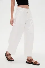 Pantalón de jean blanco de tiro medio, con diseño de silueta barrel, bolsillos clásicos y costuras con pinzas decorativas en la zona de las rodillas.