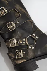 Botas de cuero negro de caña alta con hebillas plateadas y suela de goma.