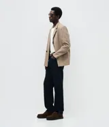 Pantalón de jean masculino con corte recto, confeccionado en algodón. Presenta un diseño clásico con cintura con presillas, cierre frontal con botón y cremallera, y bolsillos funcionales. Incluye sutiles detalles con efecto desgastado.