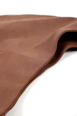 Cartera tipo hobo color marrón, con forma de media luna y correa de soga trenzada en tonos rojo y blanco.