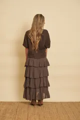 Pollera midi marrón con volados escalonados y cintura elástica.