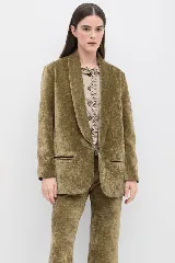Blazer de terciopelo color beige, con solapas tipo chal, cierre frontal de un botón y bolsillos laterales con solapa.