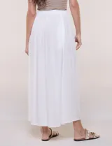 Falda larga de color blanco con pretina elastizada y fruncidos en la cintura, con caída holgada y ligera.